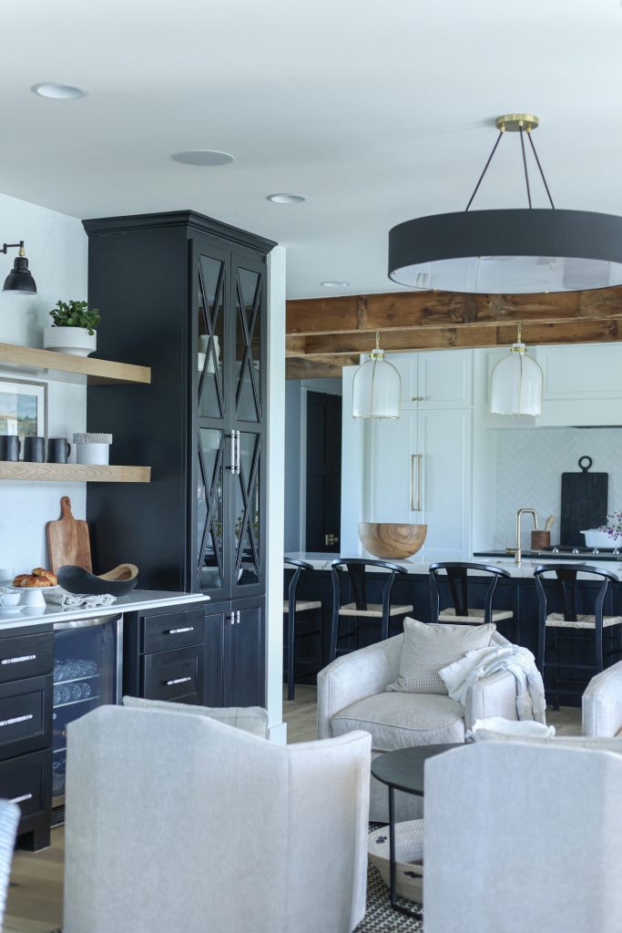 Luxury interior design by Kirkendall Design in Tulsa, OK featuring a coffee bar between living area and kitchen, with four swivel chairs for intimate gatherings and views of the outdoors.