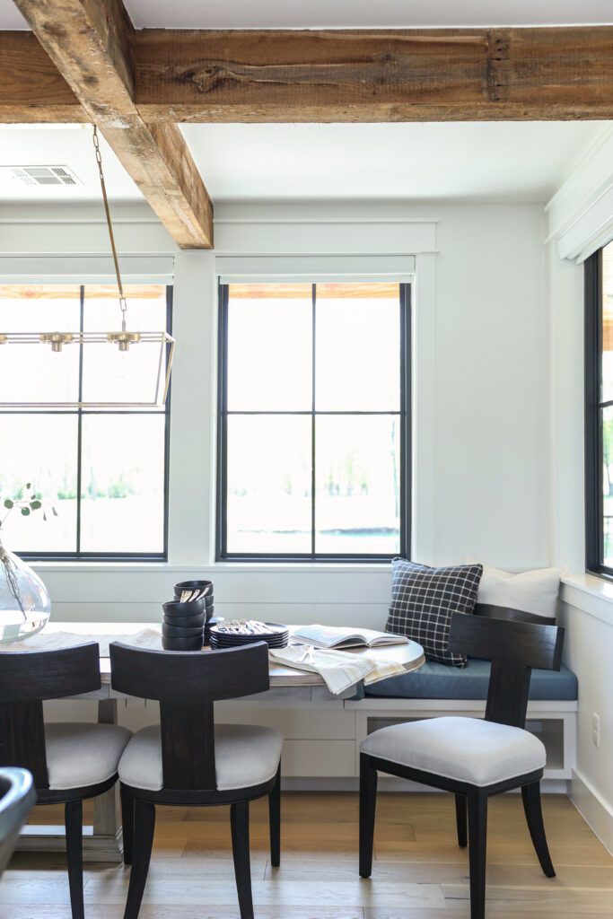 Luxury interior design by Kirkendall Design in Tulsa, OK featuring a large dining table with built-in bench seating for children on one side and chairs for adults on the other, designed for family gatherings.