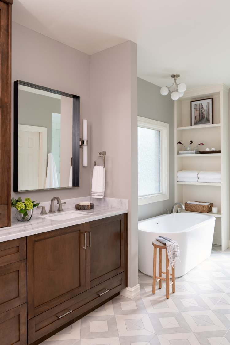 Neutral bathroom design with soaking tub and brown cabinets.