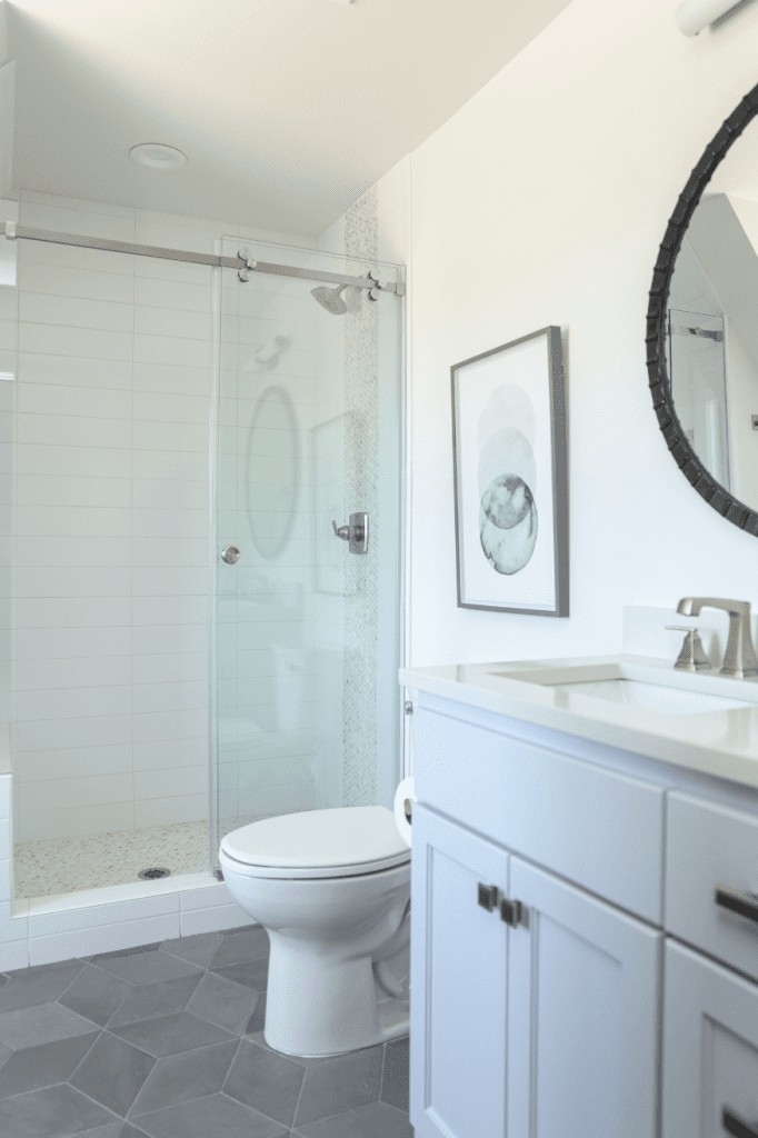 white bathroom with glass shower door interior design by Kirkendall Design in Tulsa, Oklahoma