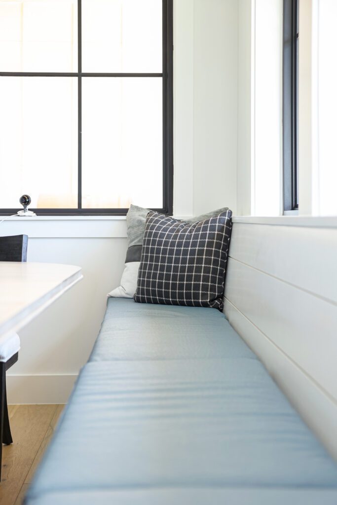 Luxury interior design by Kirkendall Design in Tulsa, OK showing a close-up of the dining bench upholstered in durable, easy-to-clean pleather fabric.