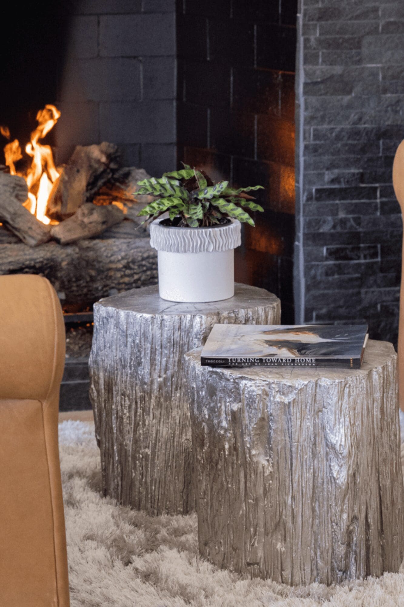 two wood stump tables in front of fireplace, luxury interior design by Kirkendall Design, Tulsa OK