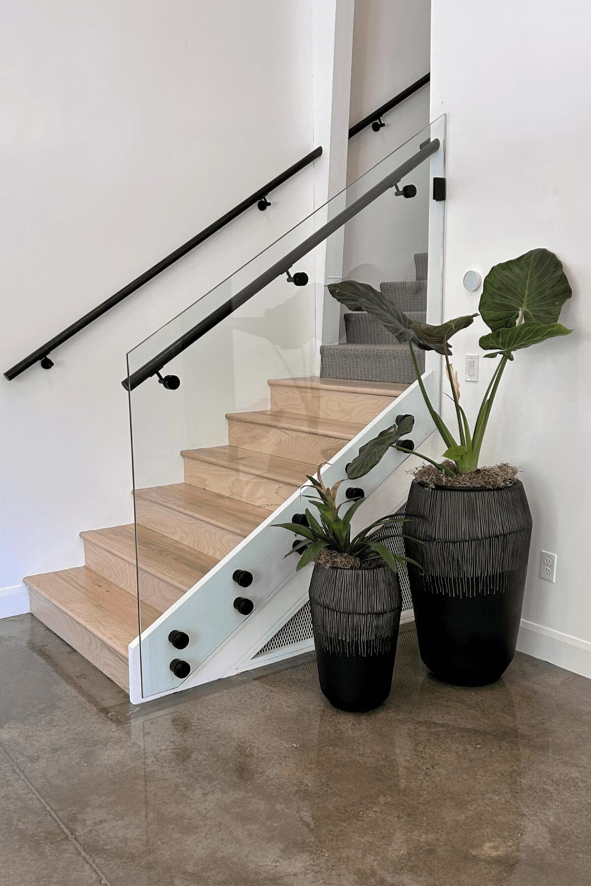 clear glass stair railing with black accents at the studio at k|d, commercial interior design by kirkendall design