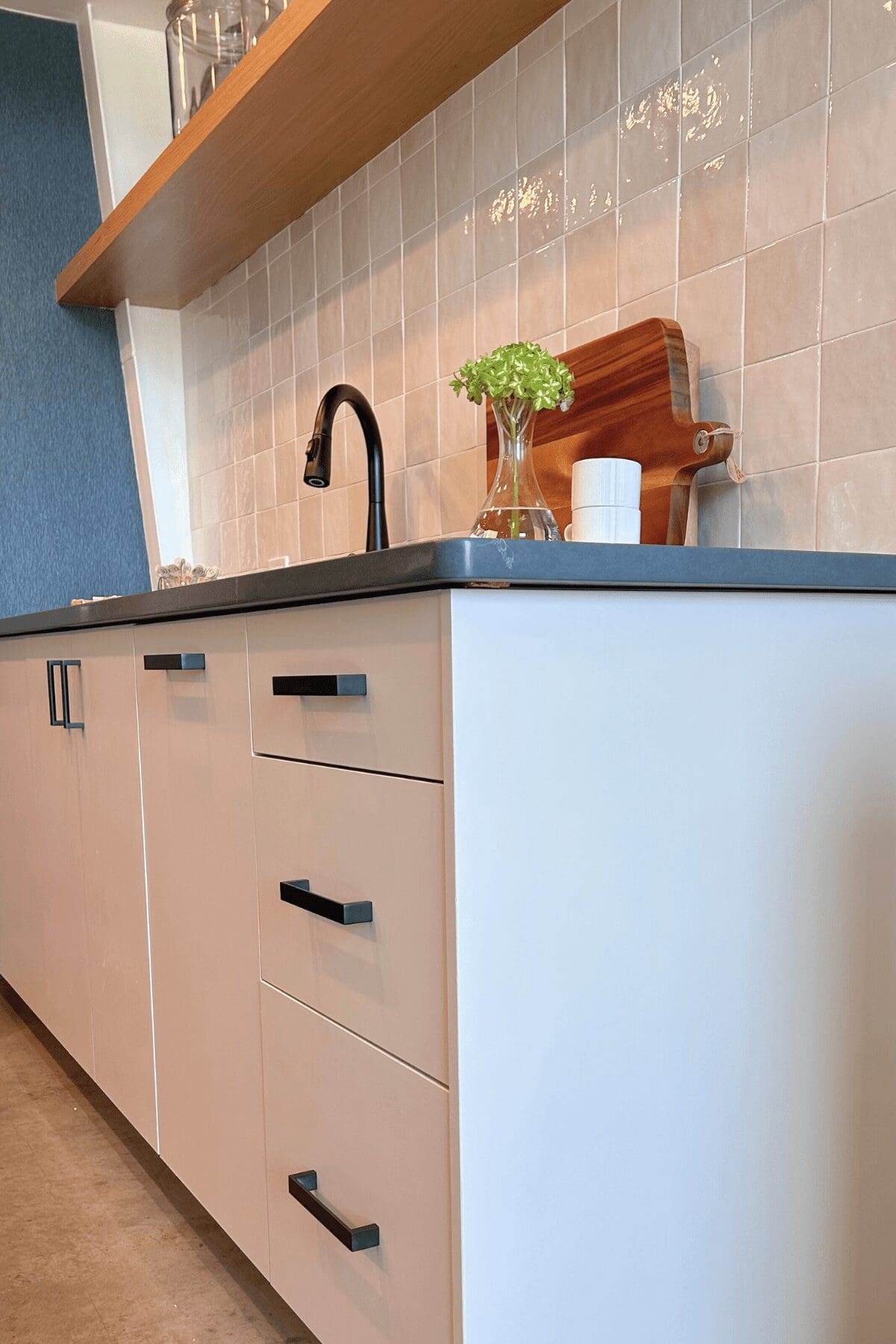 two-tone backsplash paired with blue wallpaper and floating shelf in small kitchen, commercial interior design by Kirkendall Design