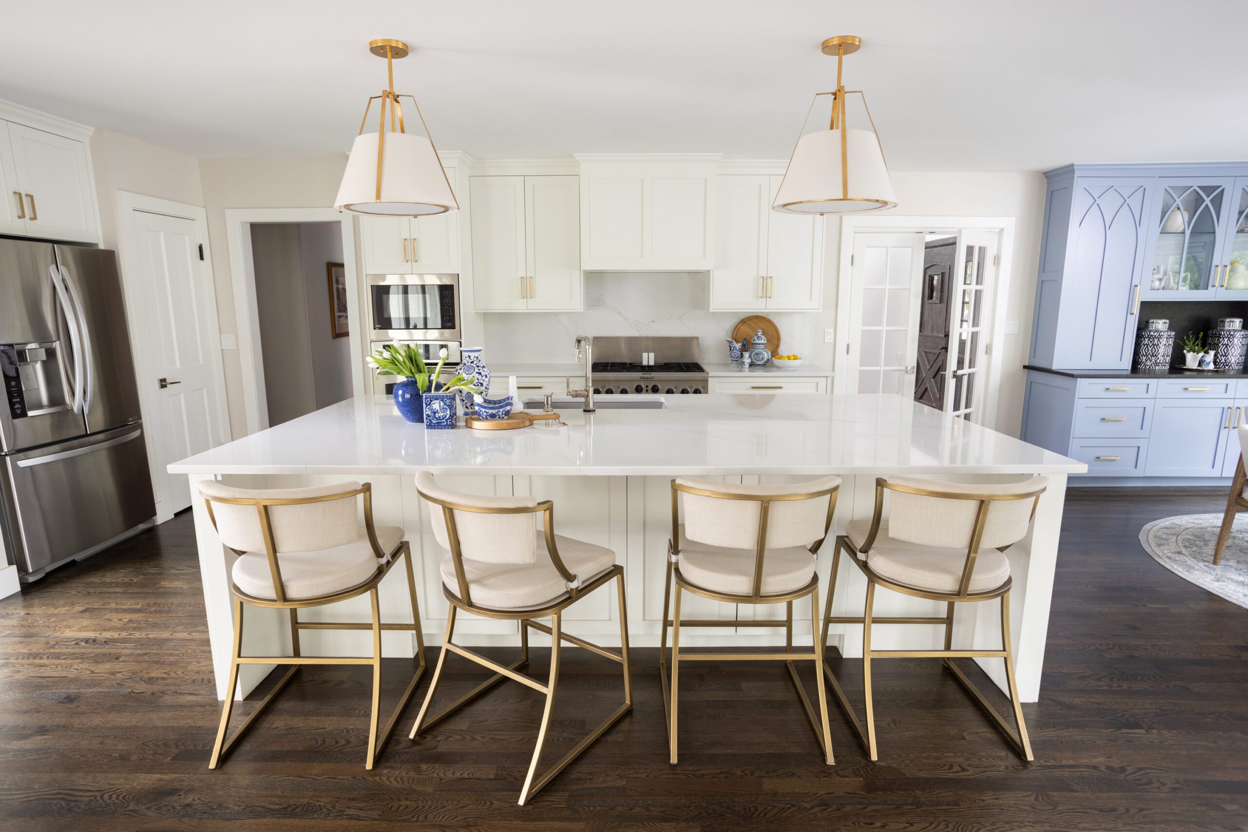open layout kitchen with white cabinets interior design by Kirkendall Design in Tulsa Oklahoma