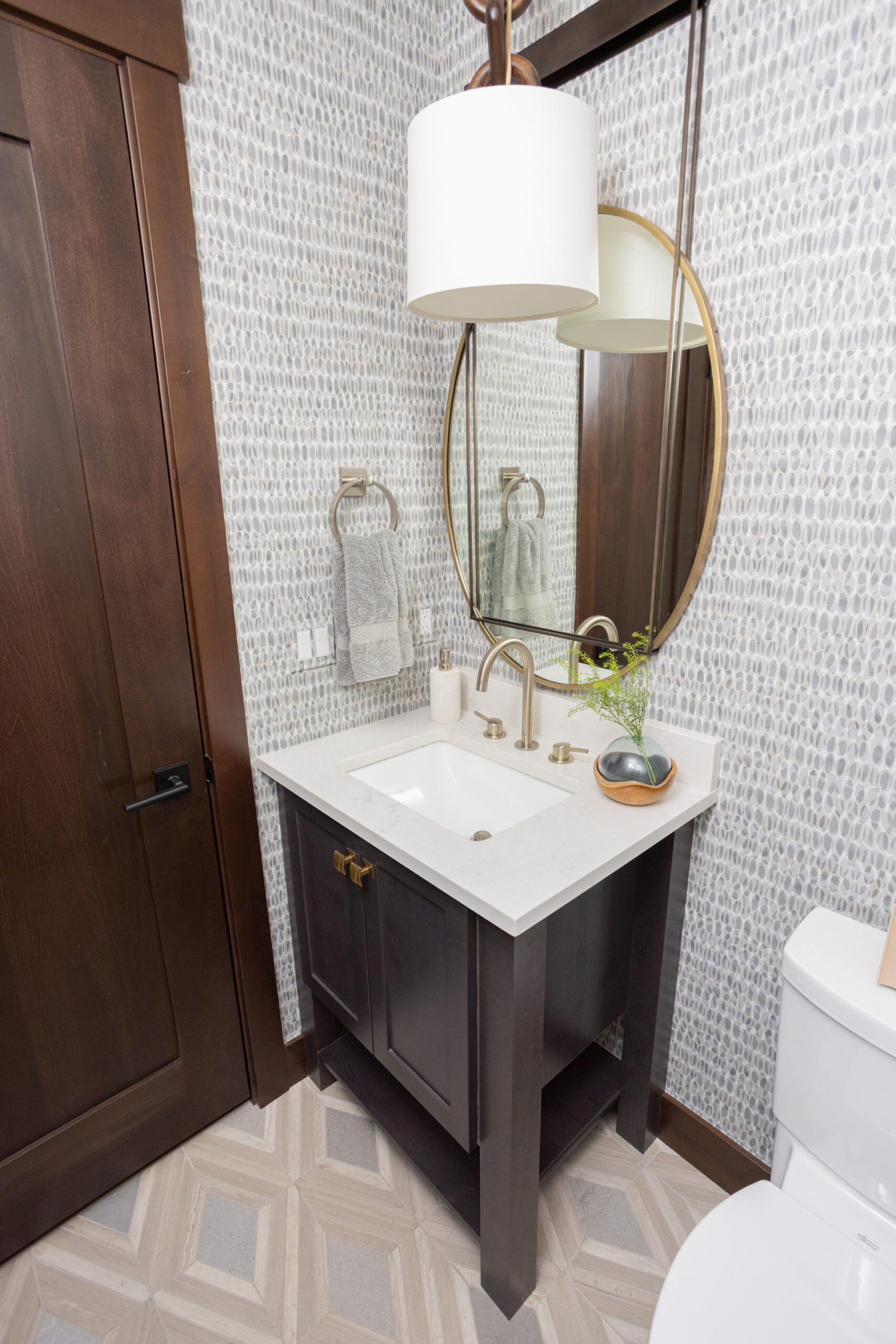 powder bathroom with gold mirror and wallpaper in silverthorne home, luxury interior design by Kirkendall Design of Tulsa, OK