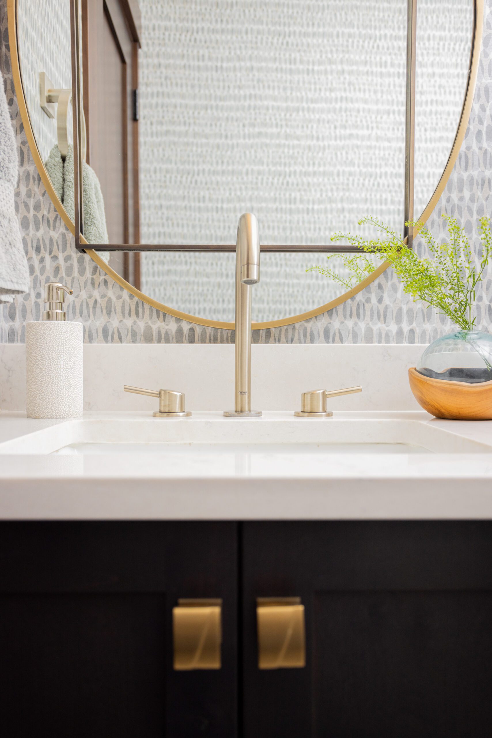 powder bathroom with gold mirror and wallpaper in silverthorne home, luxury interior design by Kirkendall Design of Tulsa, OK