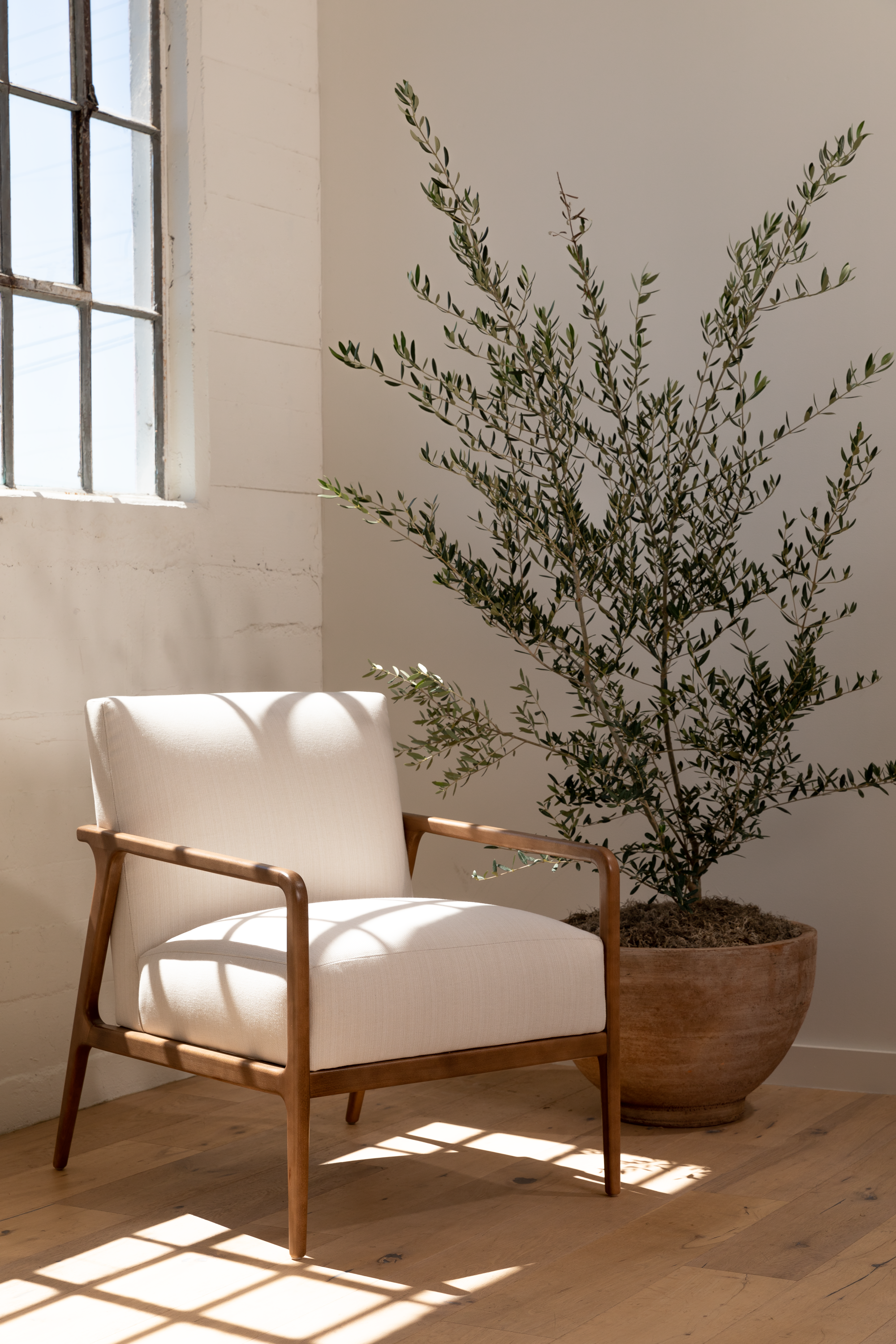 white chair with wood features showcasing Cream chair with stylish, kid-and-pet-friendly performance fabrics sourced by Kirkendall Design in Tulsa OK