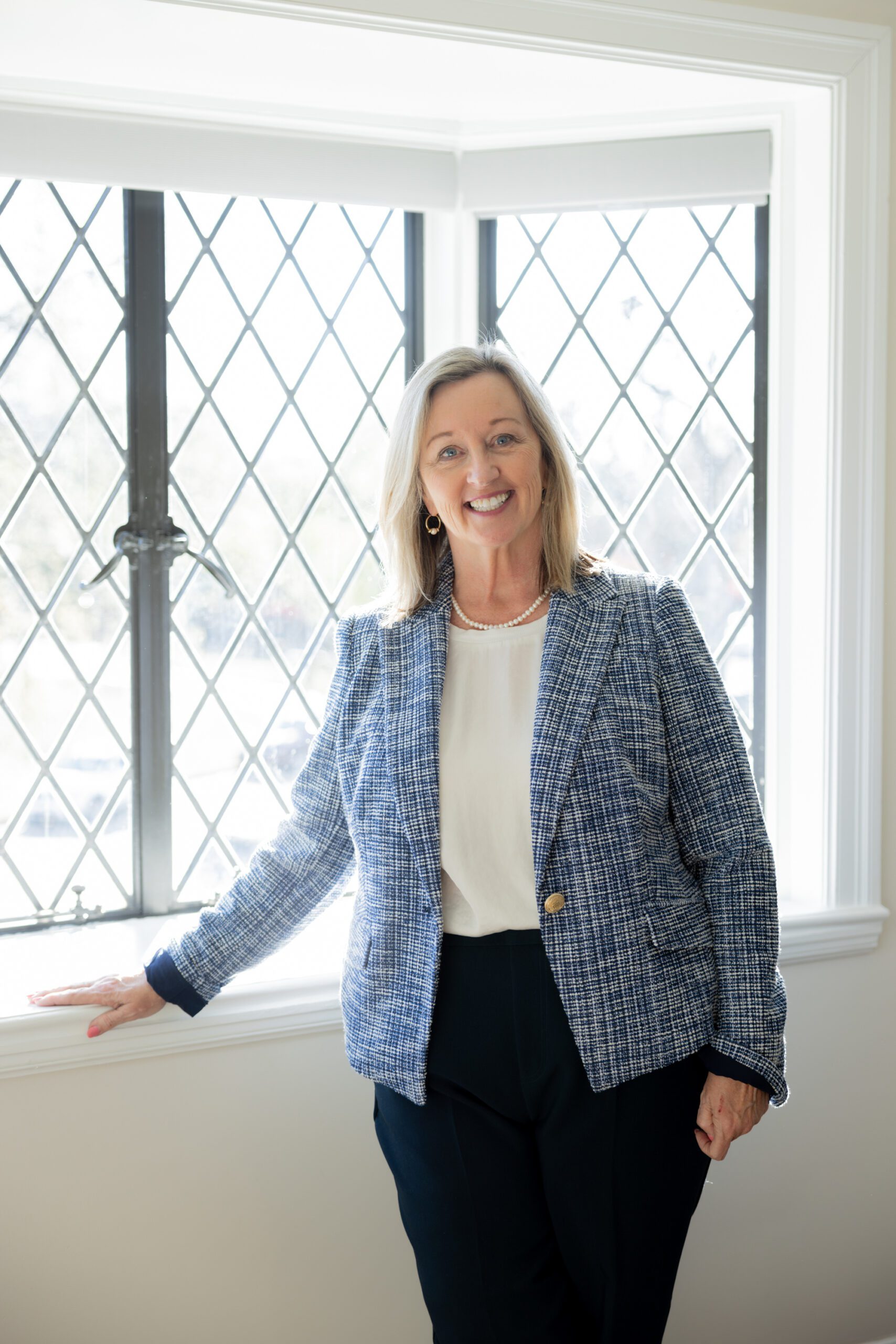 Julia Kirkendall stands in front of window at a client's home