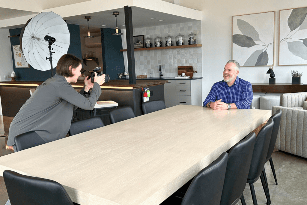 client sits at a conference room table during a professional branding photoshoot at The Studio at K|D