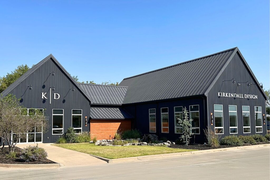 Wide angle shot of The Studio at KD in Tulsa with its all black exterior, white lettering and lush landscaping