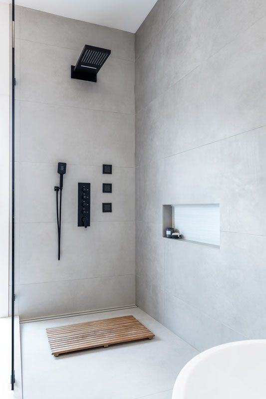 NKBA 2025 award-winning primary bathroom with luxe shower featuring large-format concrete-look tile and minimalist design.