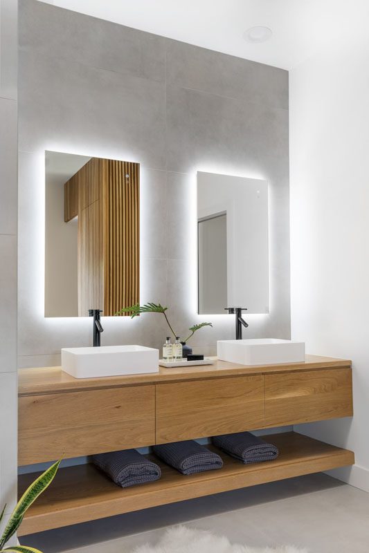 NKBA 2025 award-winning primary bathroom with floating white-oak vanity, floor-to-ceiling tile, and backlit mirrors.