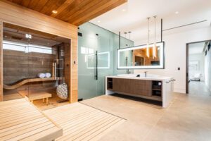 NKBA 2025 award-winning primary bathroom with glass-walled, cedar-clad sauna, and dual floating vanities.
