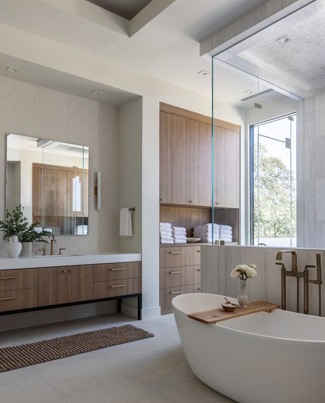 NKBA 2025 award-winning primary bathroom with warm, spa-like design featuring pony wall shower and flat slab-front cabinets.