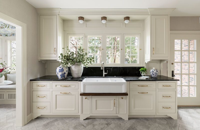 Wall of kitchen cabinet with large farmhouse sink and windows