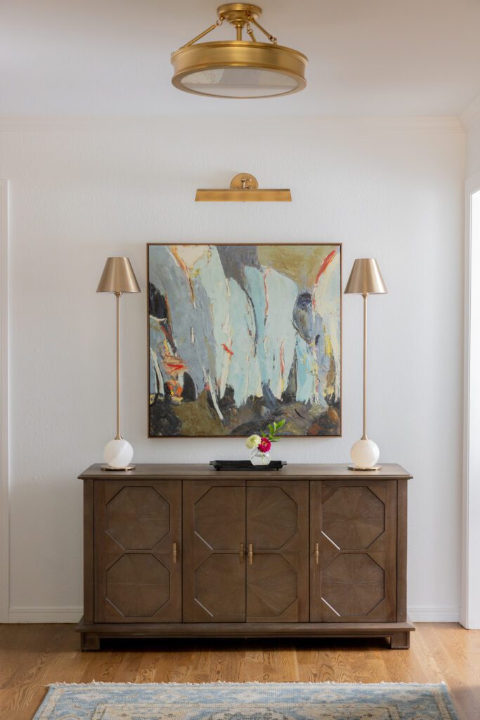 Luxury interior design by Kirkendall Design in Tulsa, OK featuring entryway style with console cabinet, artwork, and lamps