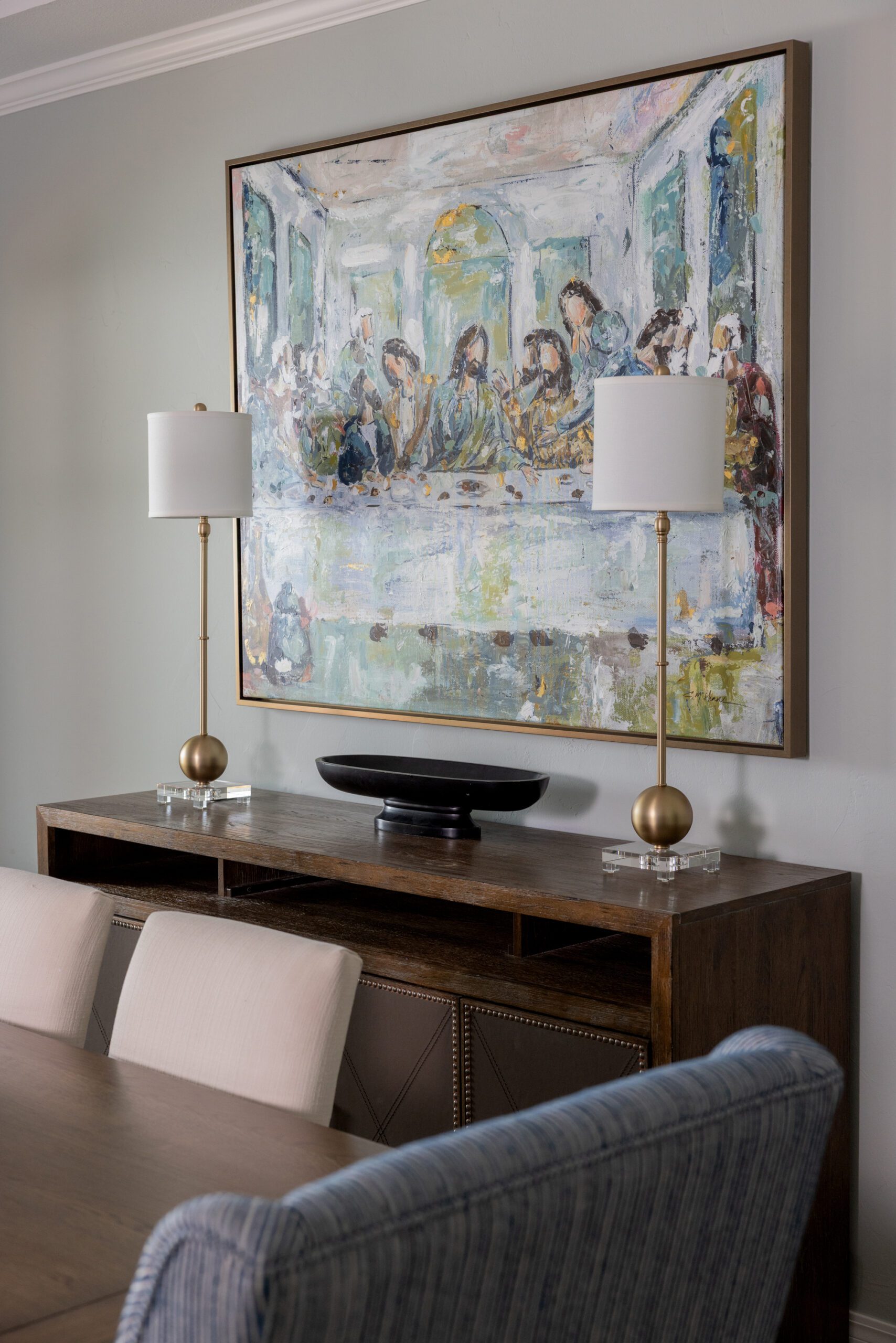 Luxury interior design by Kirkendall Design in Tulsa, OK showcasing a refreshed dining room wall with existing canvas artwork thoughtfully reframed to elevate the overall look and complement the updated furnishings.