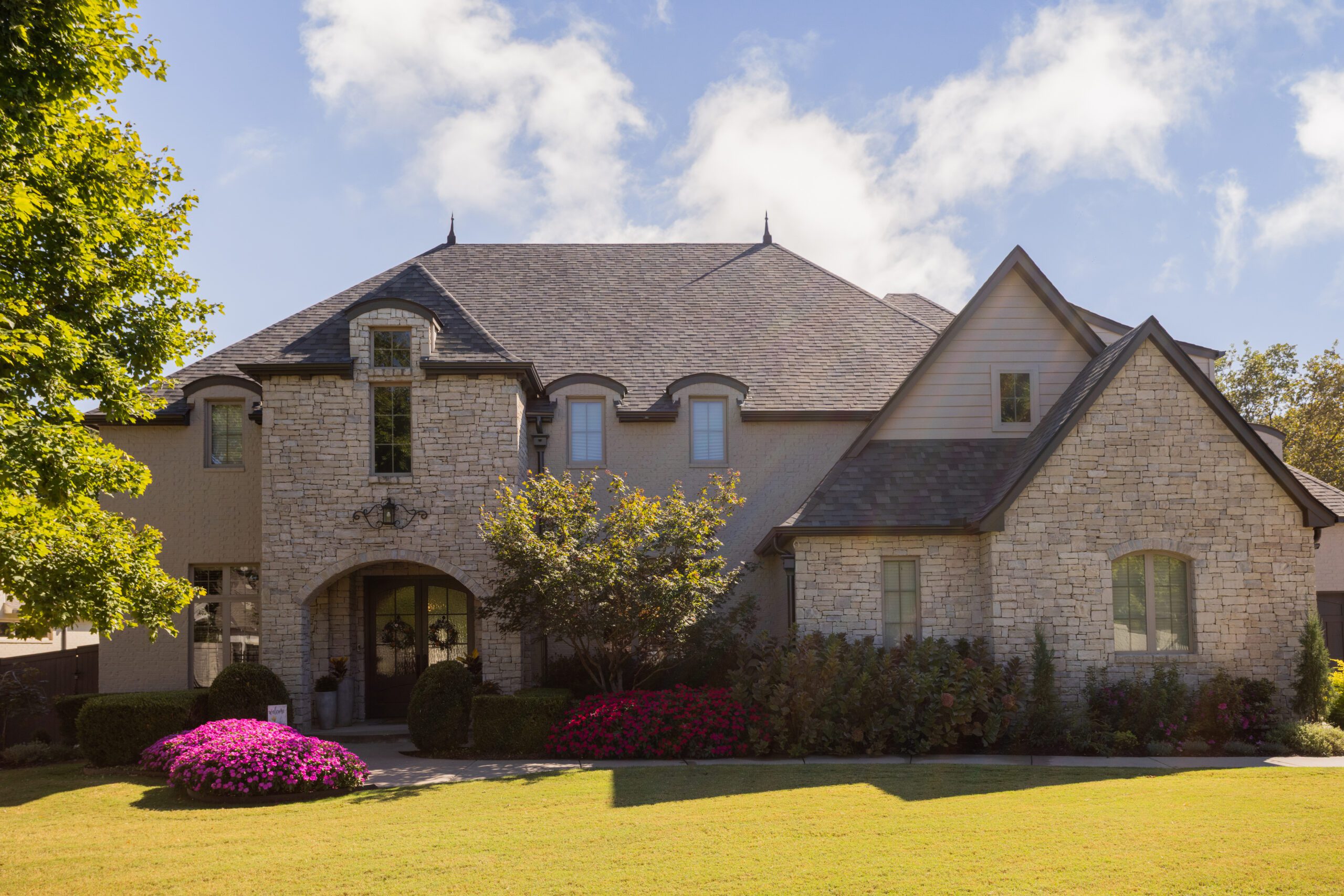 Wide view of limewashed stone exterior improving curb appeal on Tulsa home