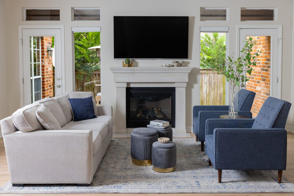 Sitting room fireplace renovation in a Tulsa home featuring a custom cast stone fireplace surround, blue and white color motif, updated finishes, and timeless interior design.