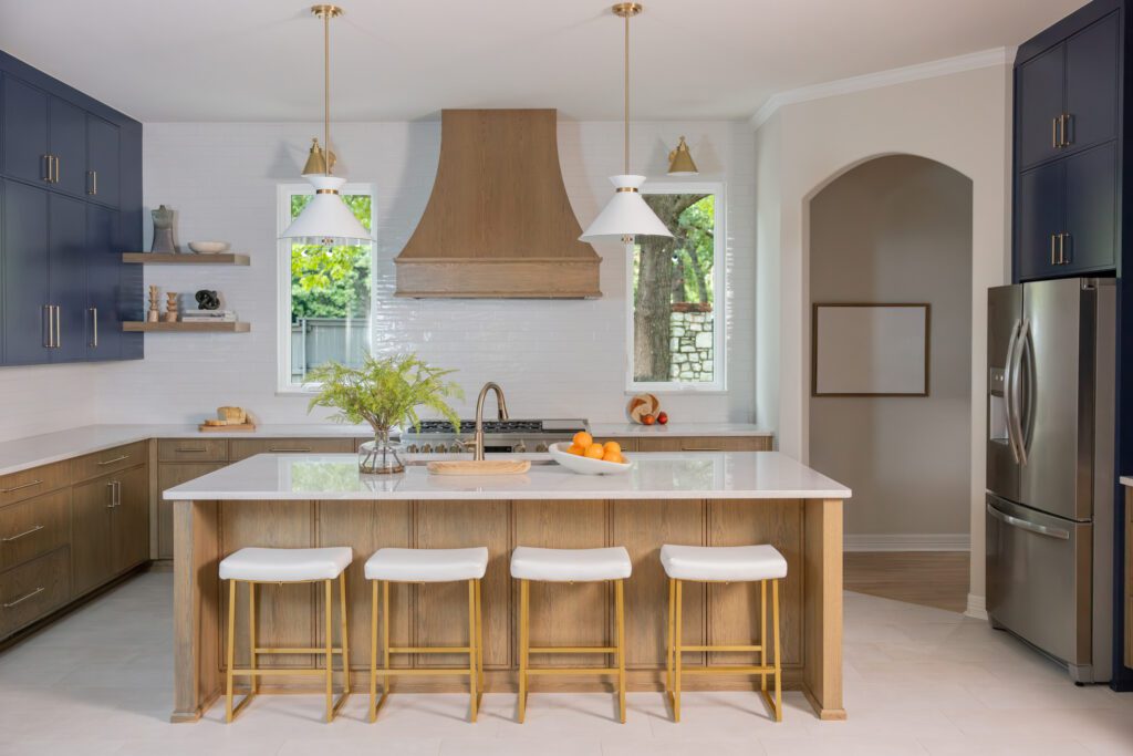 Custom Tulsa kitchen renovation featuring two-tone cabinetry with stained lower cabinets, deep blue upper cabinets, a large island, full-height tile backsplash, and luxury finishes.