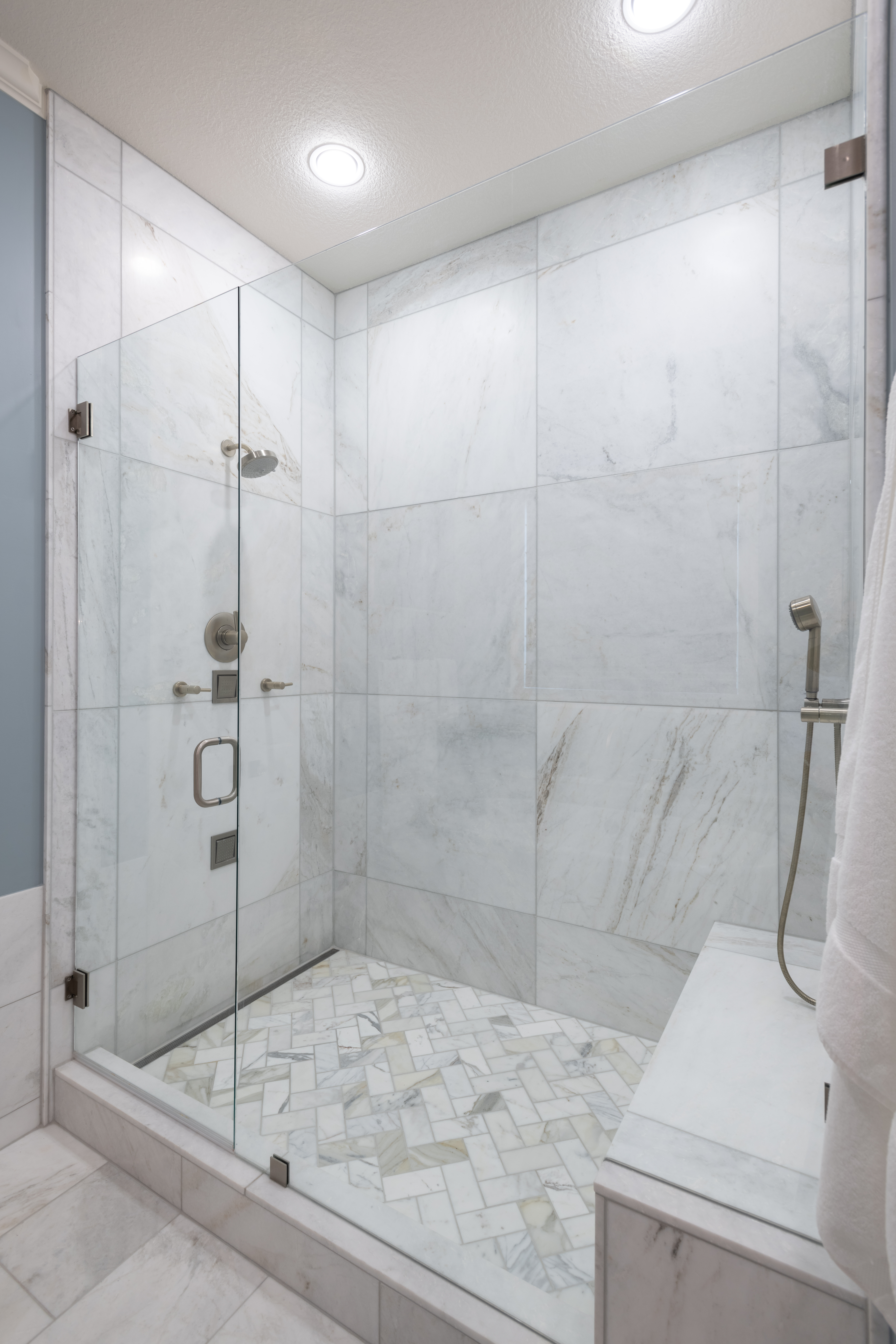 Luxury primary bathroom renovation designed by Kirkendall Design featuring marble flooring, a freestanding soaking tub, walk-in shower, and timeless spa-inspired finishes in this Tulsa multigenerational home.