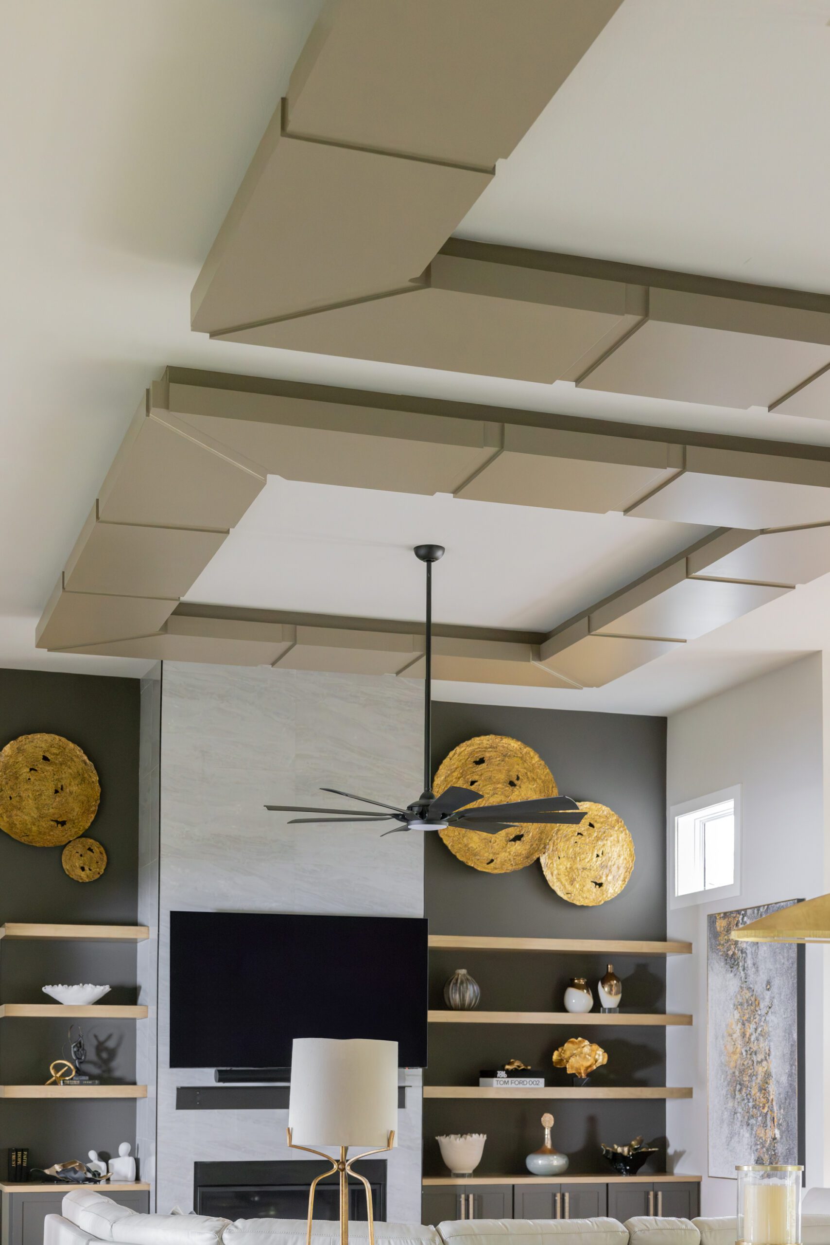 New build interior design update featuring a custom ceiling treatment painted in a deep earthy gray, creating contrast with a dark focal wall and elevated living room details