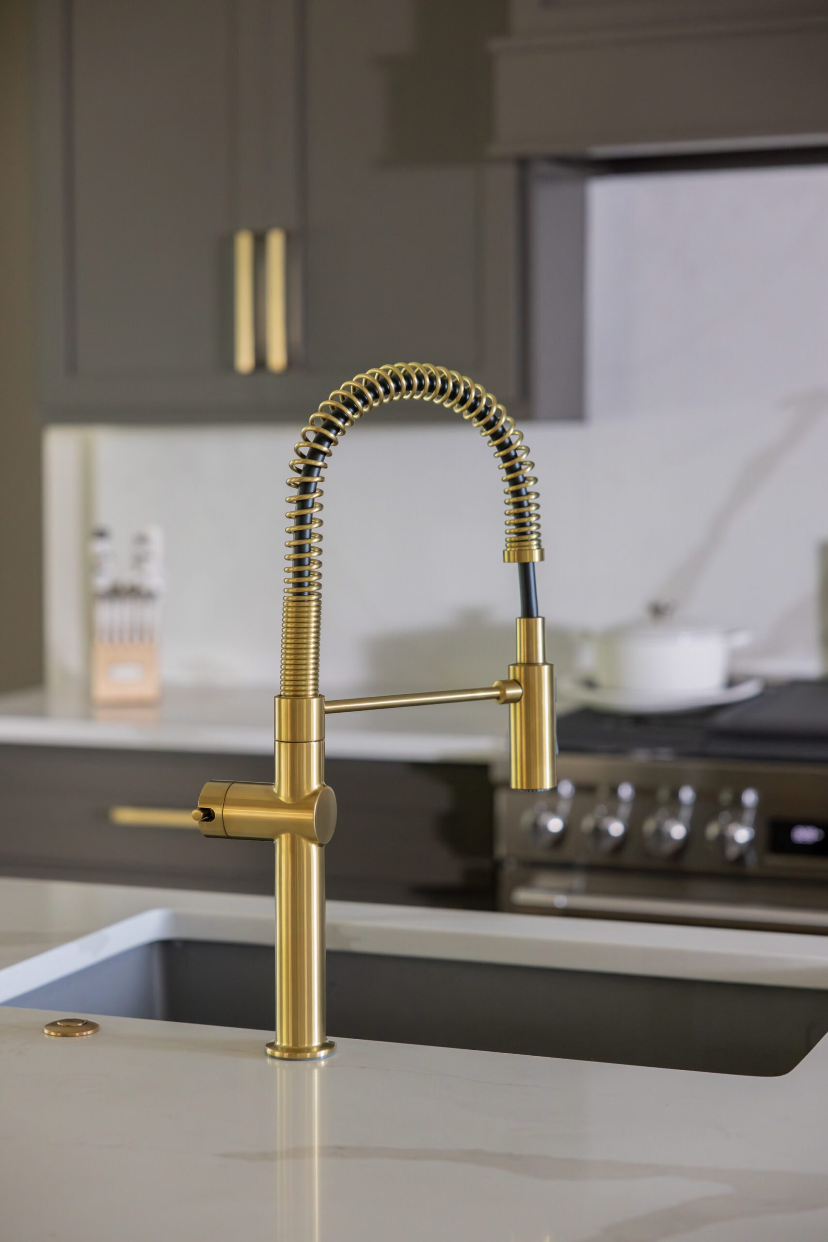 Luxury kitchen design detail featuring a gold kitchen faucet with an arched pull-down sprayer, blending modern style with timeless finishes in a Tulsa home