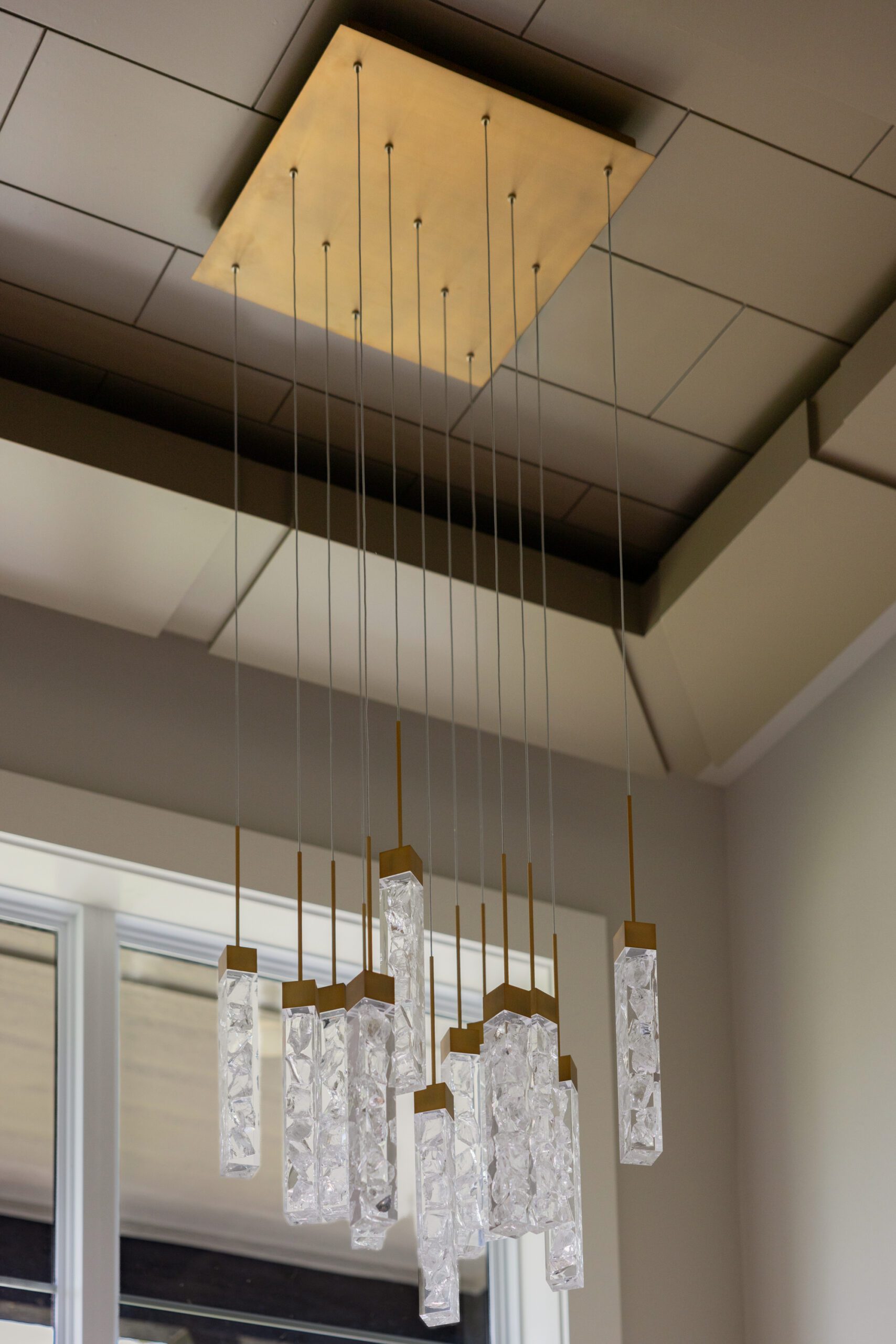 Tulsa interior design entryway featuring a statement light fixture, brown painted ceiling panel treatment, and custom architectural details that elevate a new construction home foyer