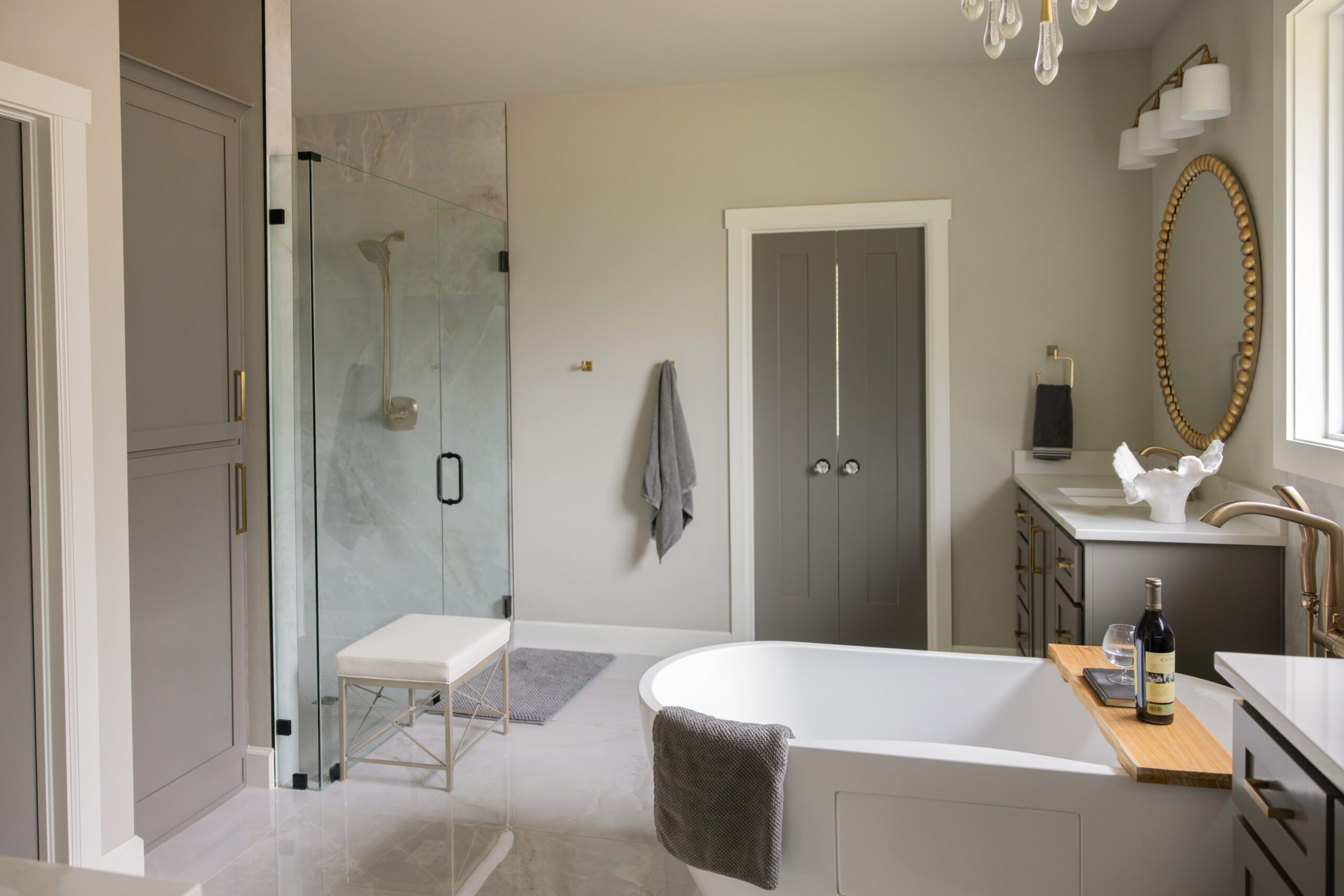 Wide-angle view of the updated primary bathroom in a new build Tulsa home, showcasing the walk-in shower, freestanding tub, and redesigned vanity—proof that thoughtful interior design can completely transform a new construction home