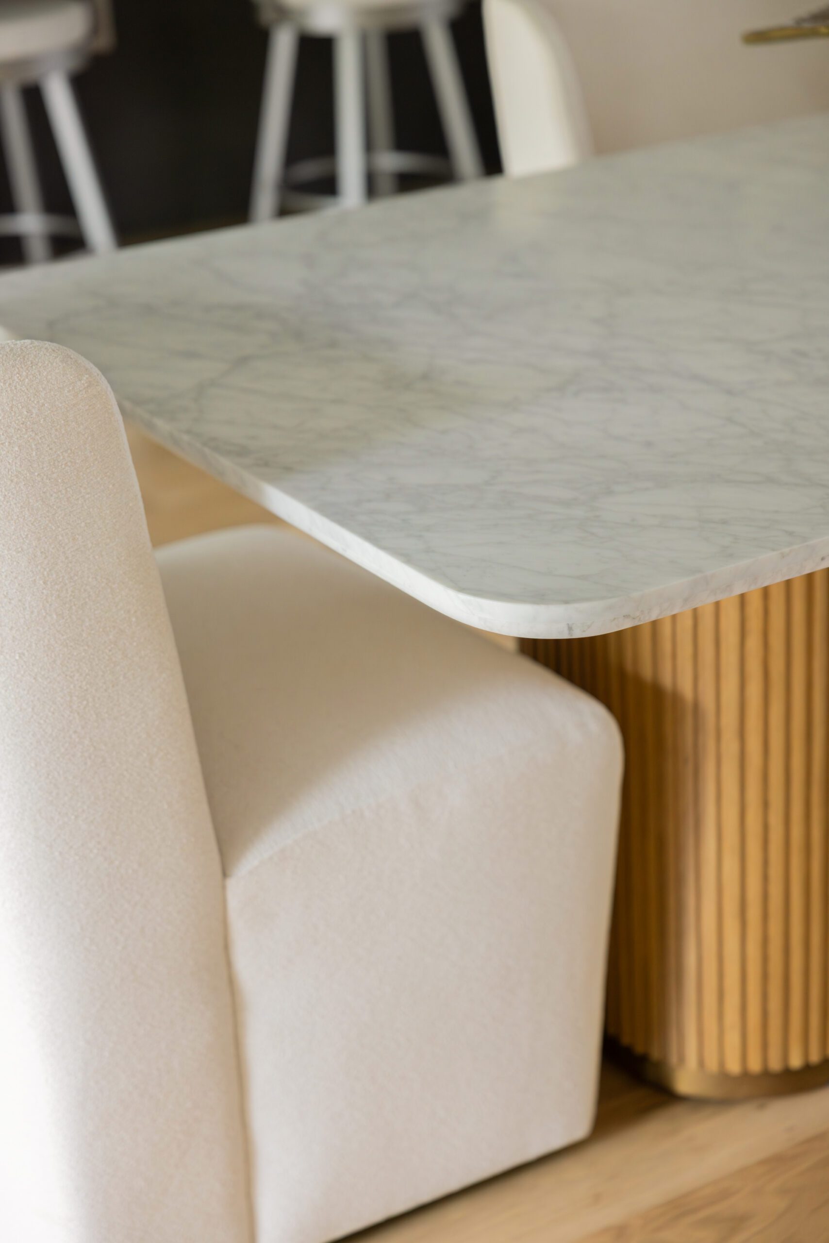 Luxury dining room design in a Tulsa new construction home featuring a modern wingback cream dining chair, elegant table